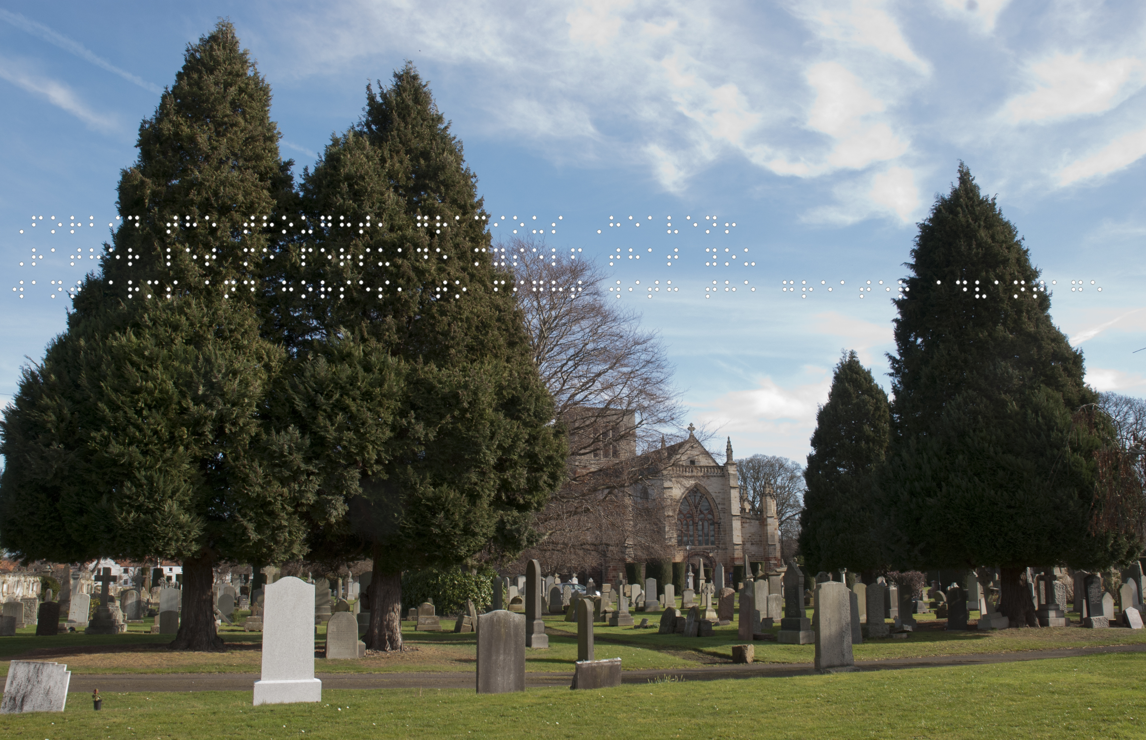 Foreground graveyard. Behind the trees is St Marys Church, all under a blue sky. Quote taken from historical figure shown in Braille