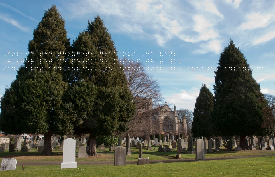 Foreground graveyard. Behind the trees is St Marys Church, all under a blue sky. Quote taken from historical figure shown in Braille