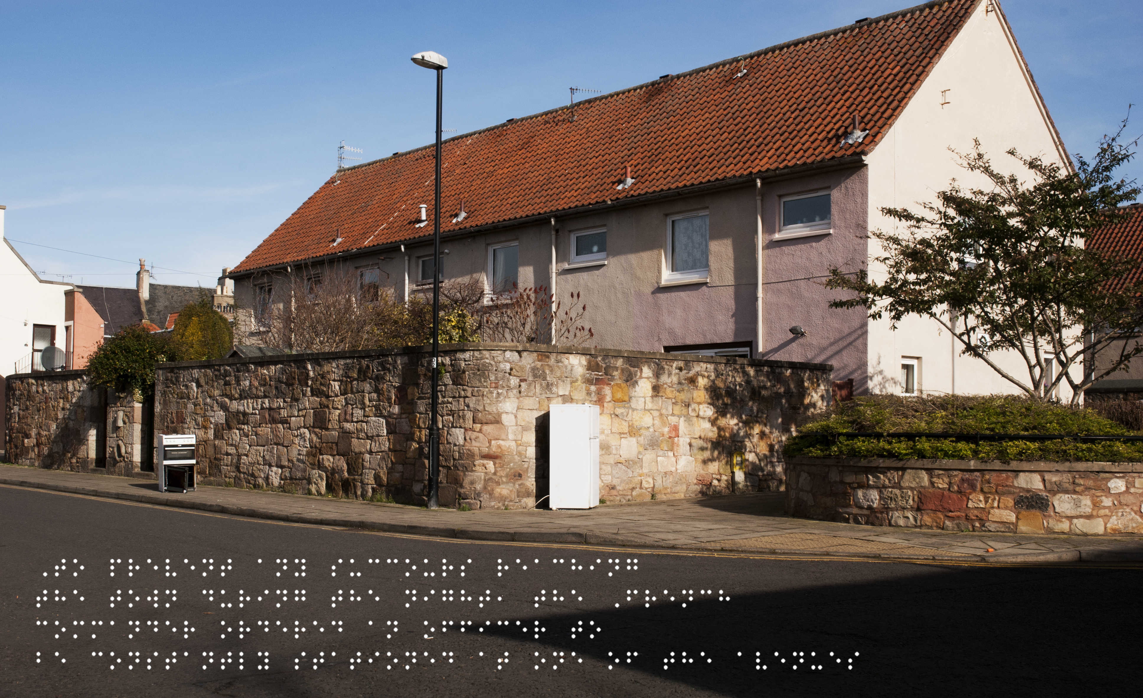 New housing but with fridge and cooker abandoned in the street. Quote taken from historical figure shown in Braille